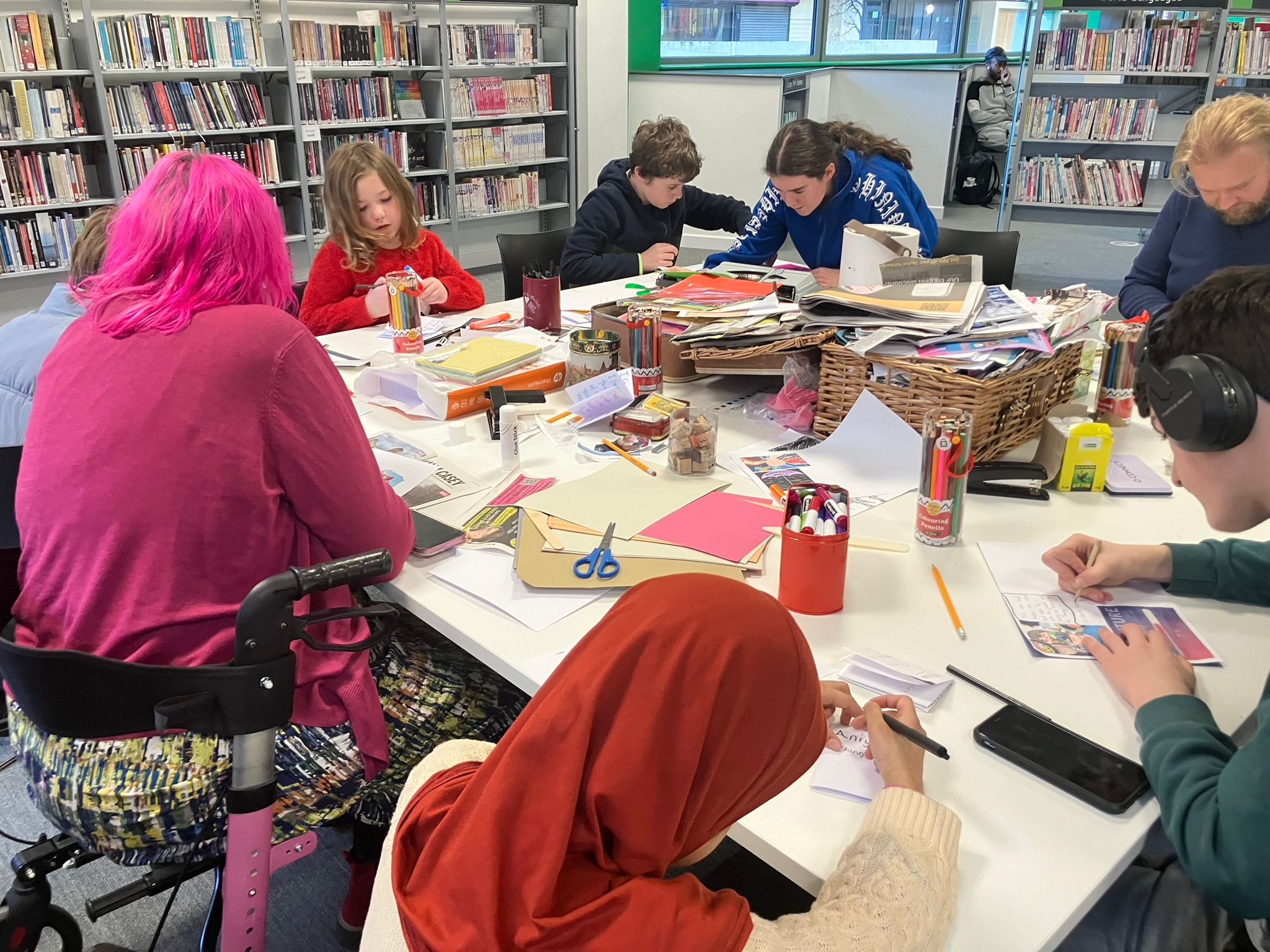 Zine making in Newcastle, young people are seated looking with concentration at their work